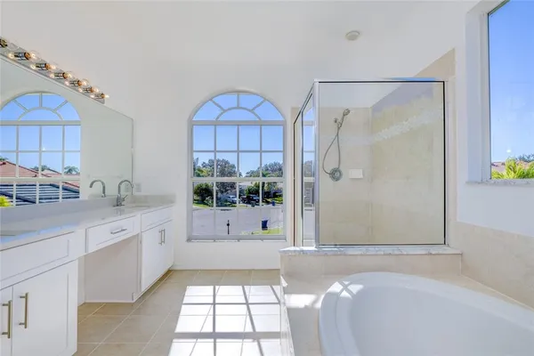 a bathroom with a double vanity sink a mirror and a bathtub