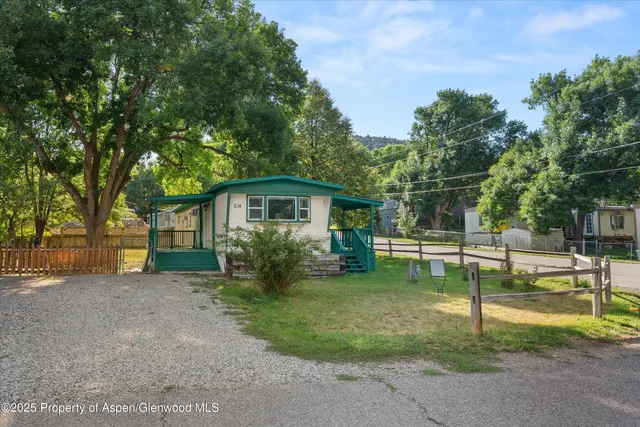 a view of a house with a yard and tree s