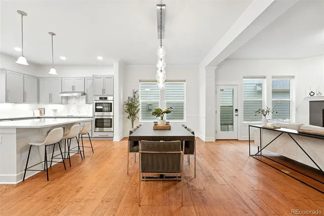 a living room with stainless steel appliances kitchen island granite countertop wooden floor a dining table and chairs