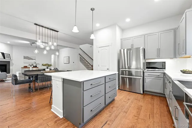 a kitchen with a refrigerator a sink and dishwasher a oven with wooden floor
