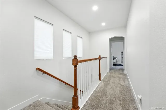 a view of a hallway with wooden floor and stairs