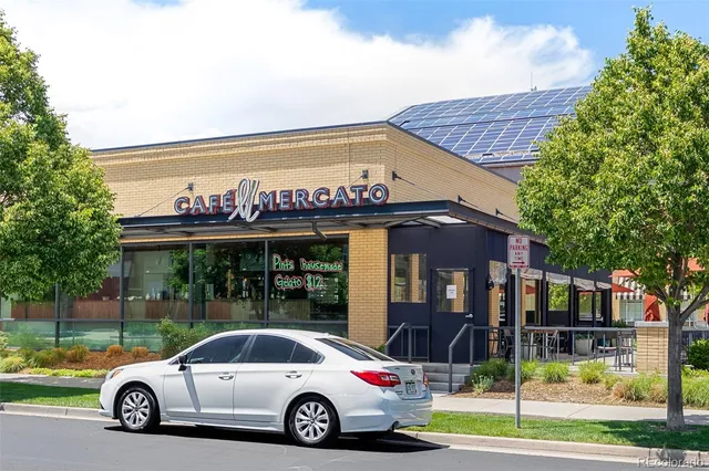 a view of a building with a yard and table and chairs in patio