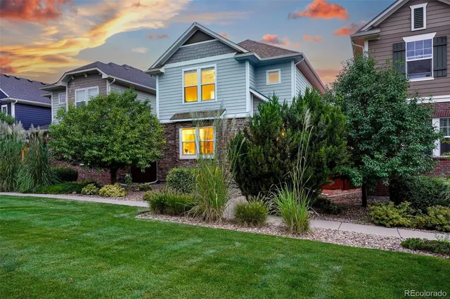 a front view of a house with a yard and trees