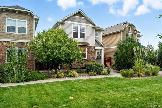 a front view of a house with a yard and trees