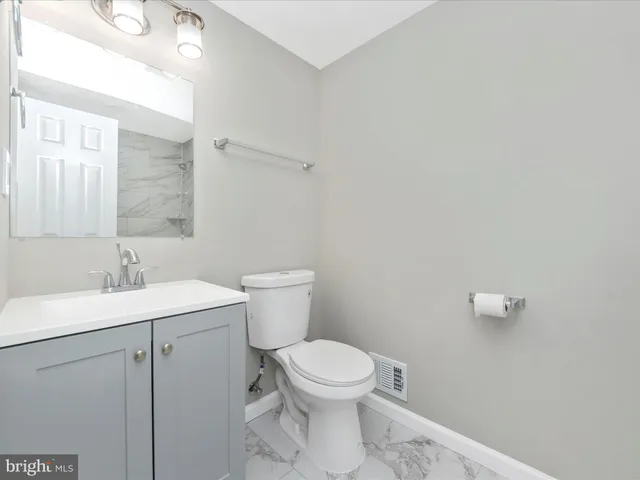 a bathroom with a toilet a sink and mirror
