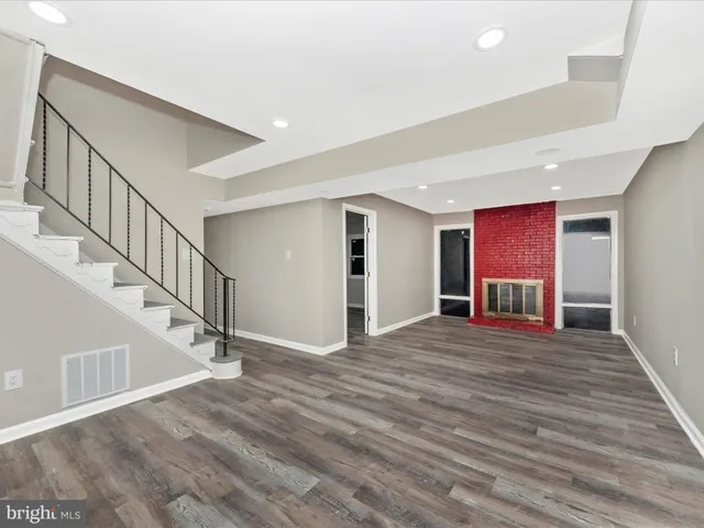 a view of a livingroom with wooden floor and stairs