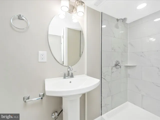 a bathroom with a sink a mirror and shower