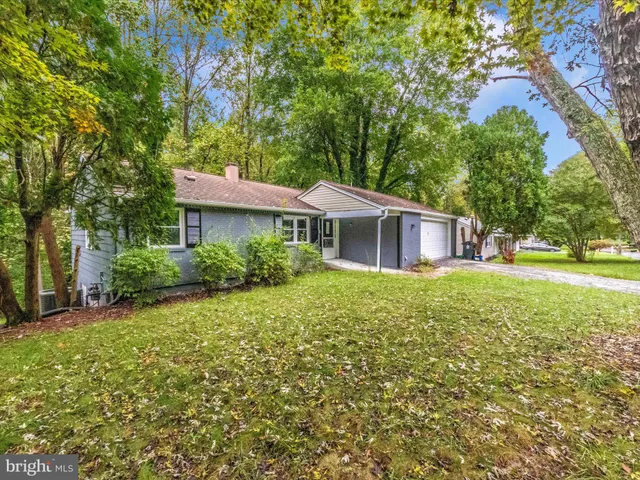 a front view of a house with yard and green space