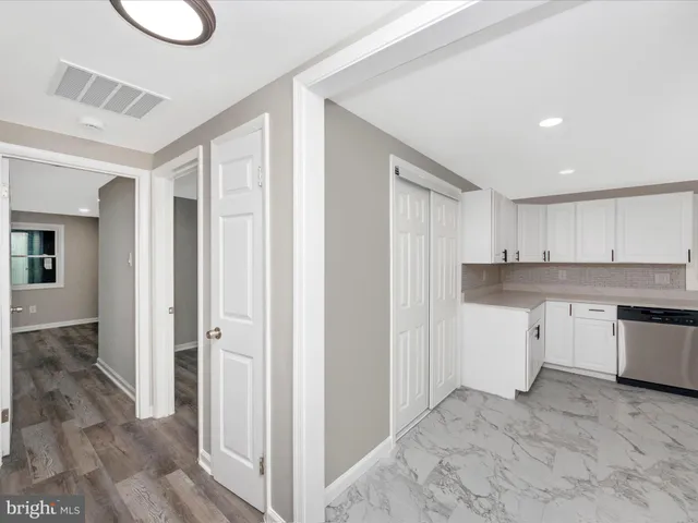 a kitchen with white cabinets and sink