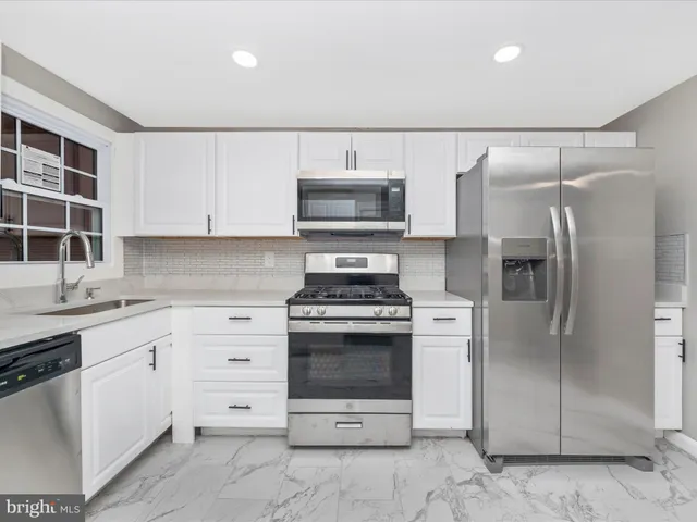 a kitchen with stainless steel appliances granite countertop a stove and a refrigerator