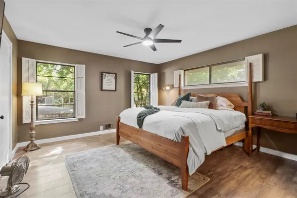 a bed sitting in a spacious bedroom next to a window