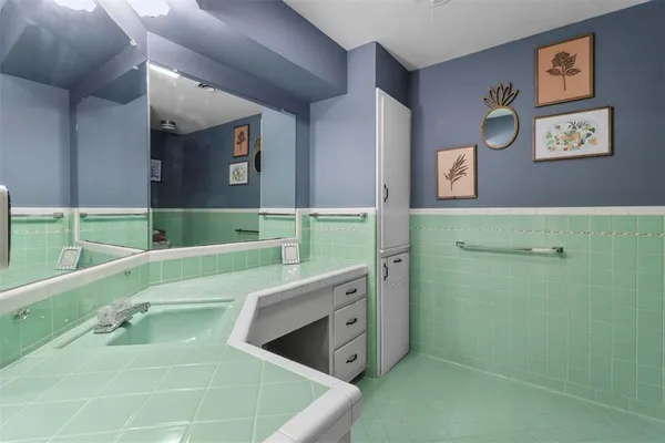 a bathroom with a tub sink and mirror