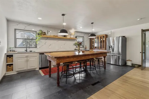 a kitchen with a table chairs sink and cabinets