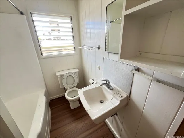 a bathroom with a sink a toilet and a window