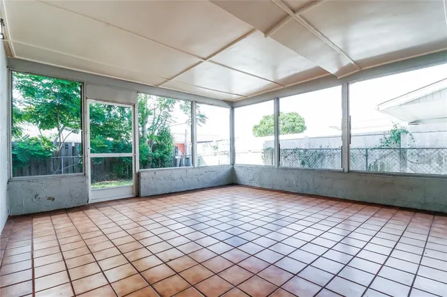 a view of empty room with windows and large tree