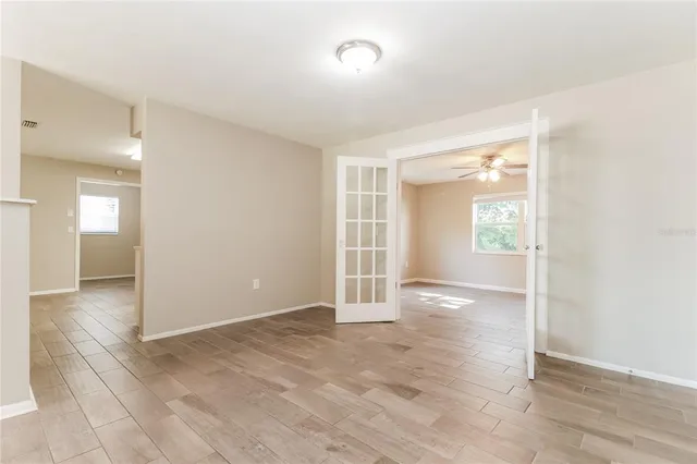 an empty room with wooden floor and windows