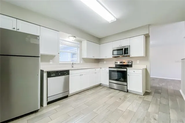 a kitchen with white cabinets and white appliances