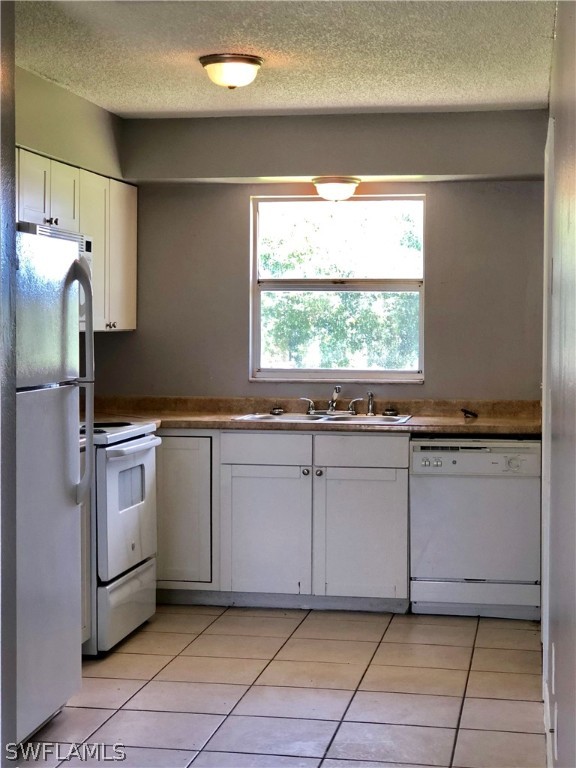 19076 Coconut Road Fort Myers, FL 33967 - Photo 8 of 8 a kitchen with granite countertop white cabinets and white appliances