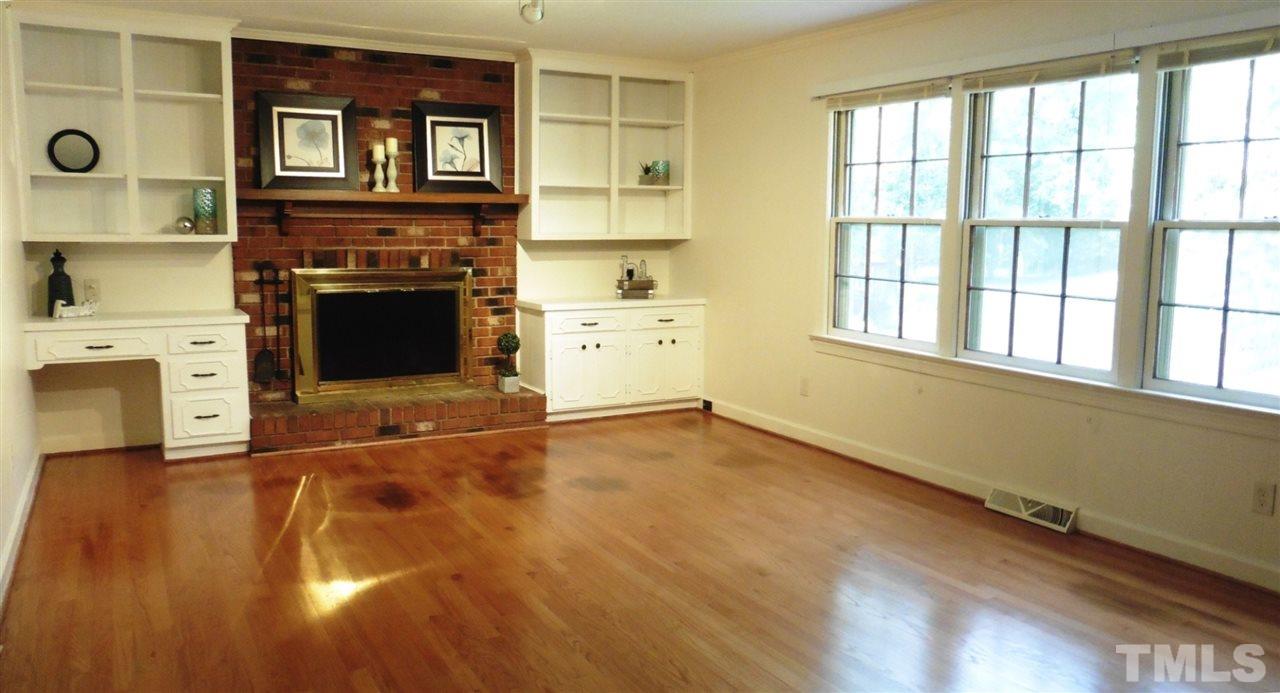 1120 Country Ridge Drive Raleigh, NC 27609 - Photo 7 of 25 The huge Family Rm offers a hardwood floor, crown molding, track lighting, brick FP flanked by desk, freshly painted cabinets & bookshelves plus another wall of cabinetry & triple windows overlooking the backyard.