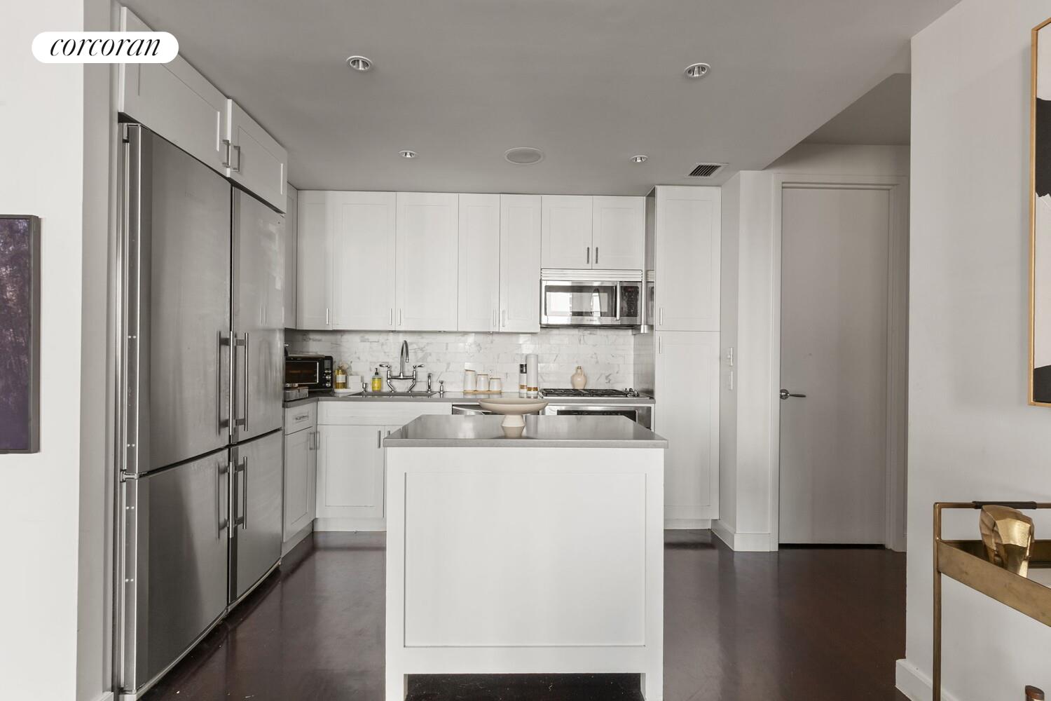 333 Rector Place, Unit 1009 Manhattan, NY 10280 - Photo 4 of 11 a kitchen with stainless steel appliances a refrigerator sink and cabinets