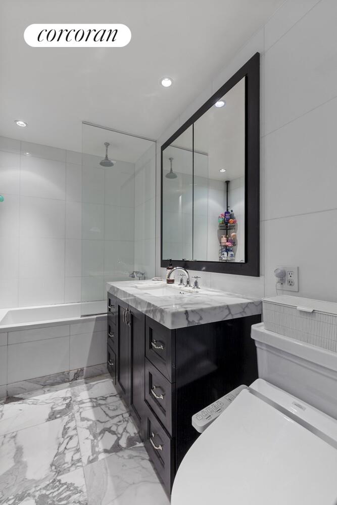 333 Rector Place, Unit 1009 Manhattan, NY 10280 - Photo 6 of 11 a bathroom with a sink and mirror