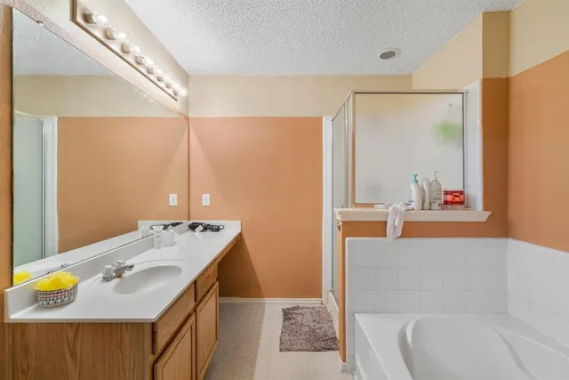 a en suite bathroom with a tub sink and mirror