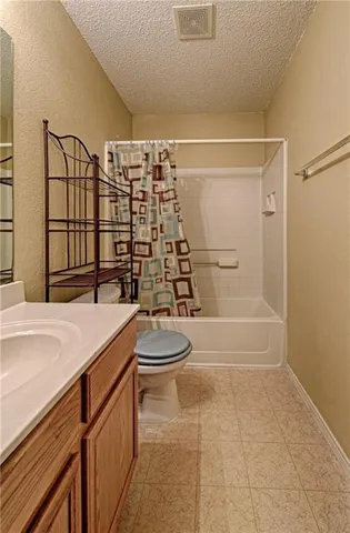 a bathroom with a granite countertop sink a toilet and shower