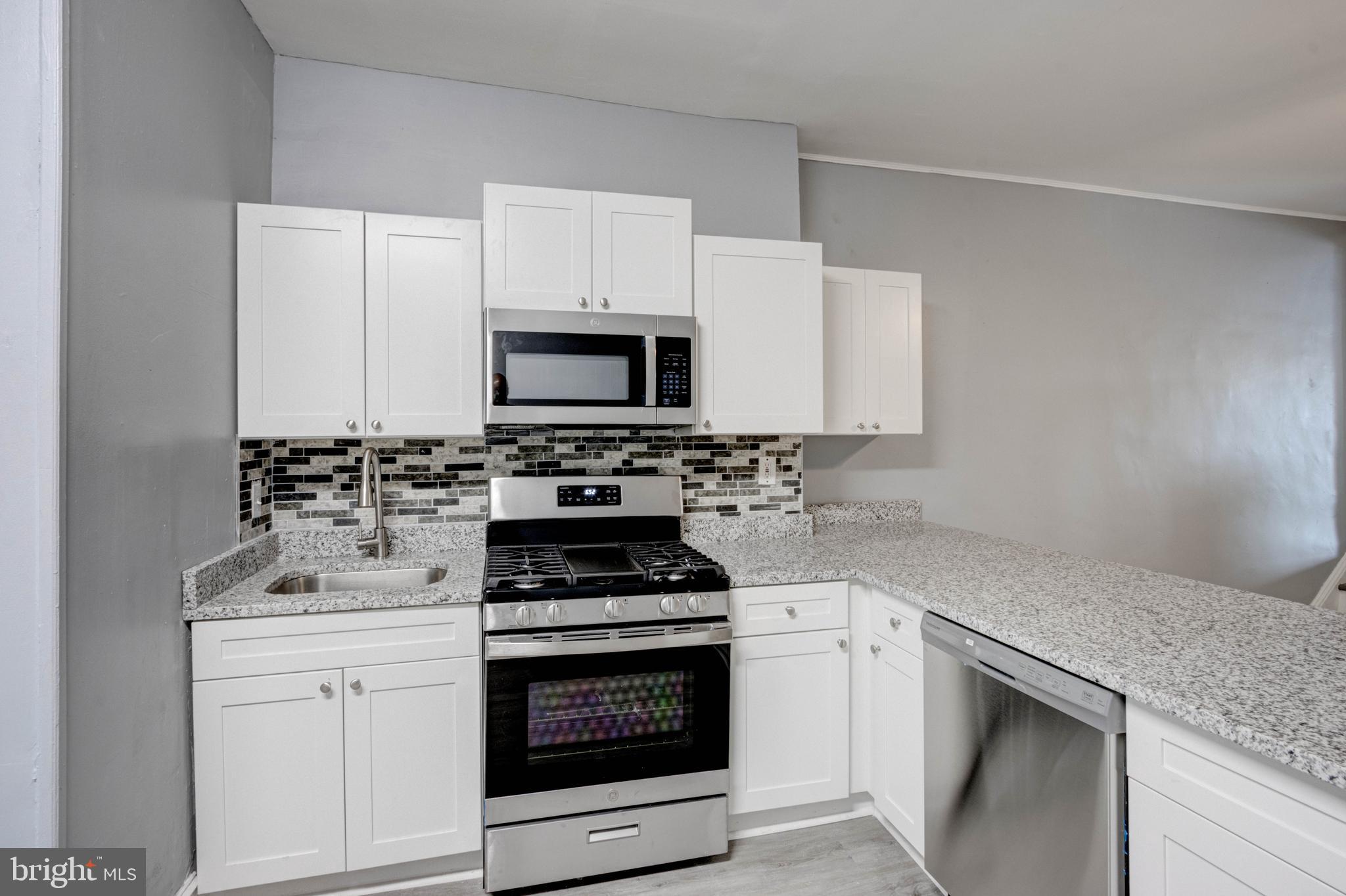 3438 Belair Road Baltimore, MD 21213 - Photo 8 of 36 a kitchen with white cabinets appliances and sink