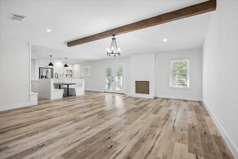 a view of empty room with wooden floor and windows