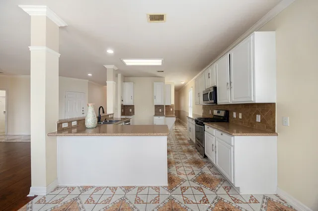 a large white kitchen with stainless steel appliances