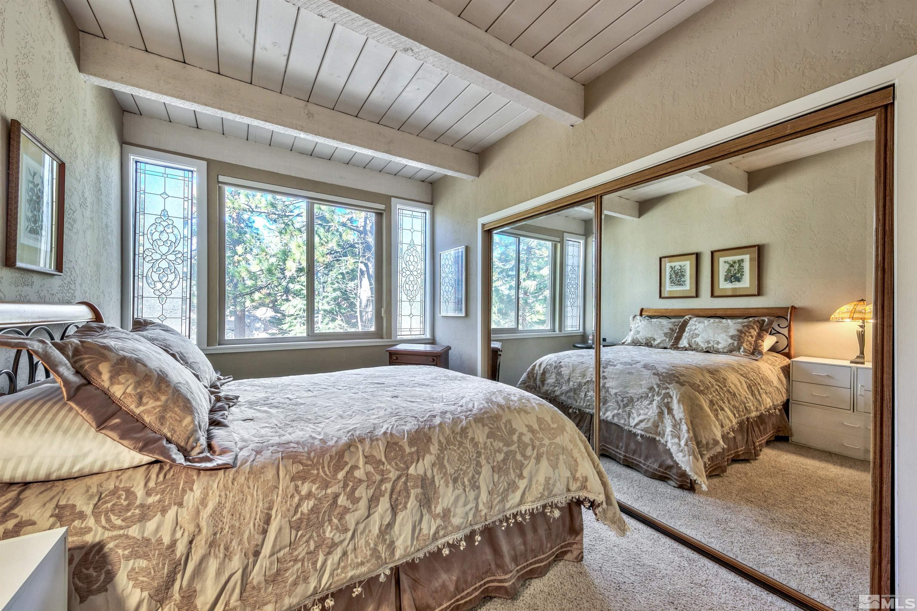 26 Cascade Court Stateline, NV 89449 - Photo 15 of 30 a bedroom with a bed a lamp and a large window