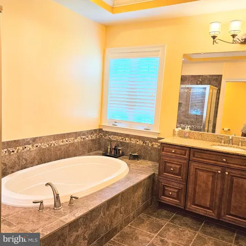 an empty room with wooden floor and a ceiling fan