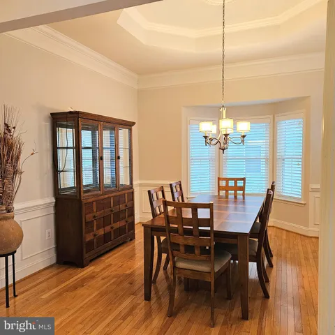a dining room with furniture a chandelier and wooden floor