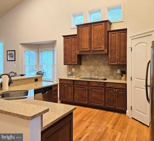 a living room with couches and kitchen view with wooden floor