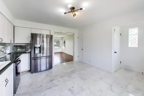 a view of a kitchen with a sink and refrigerator