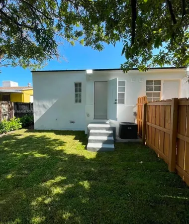 a view of a house with backyard and a tree