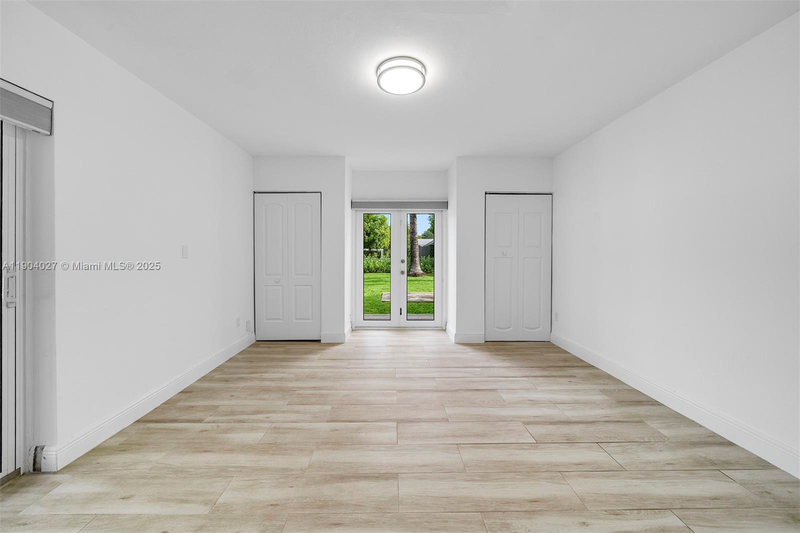 7575 Southwest 134th Street Pinecrest, FL 33156 - Photo 20 of 28 a view of an empty room with wooden floor and a window