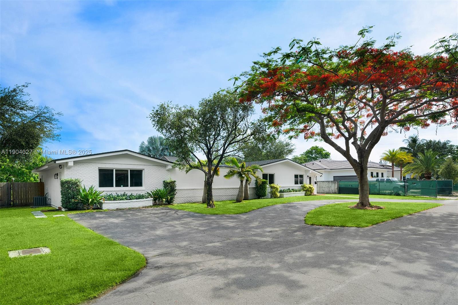 7575 Southwest 134th Street Pinecrest, FL 33156 - Photo 2 of 28 a front view of a house with garden and trees