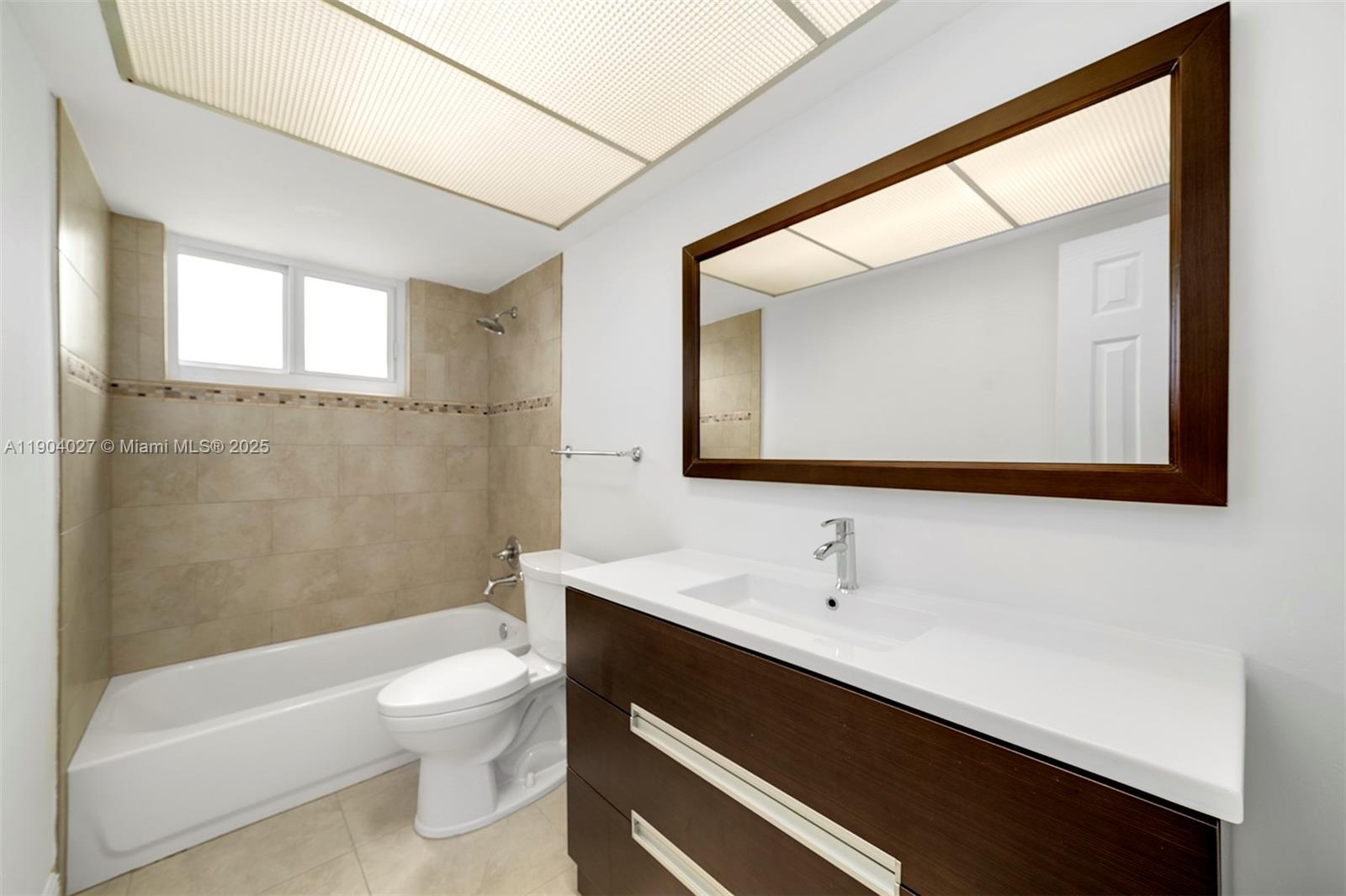 7575 Southwest 134th Street Pinecrest, FL 33156 - Photo 21 of 28 a bathroom with a sink a toilet a mirror and bathtub