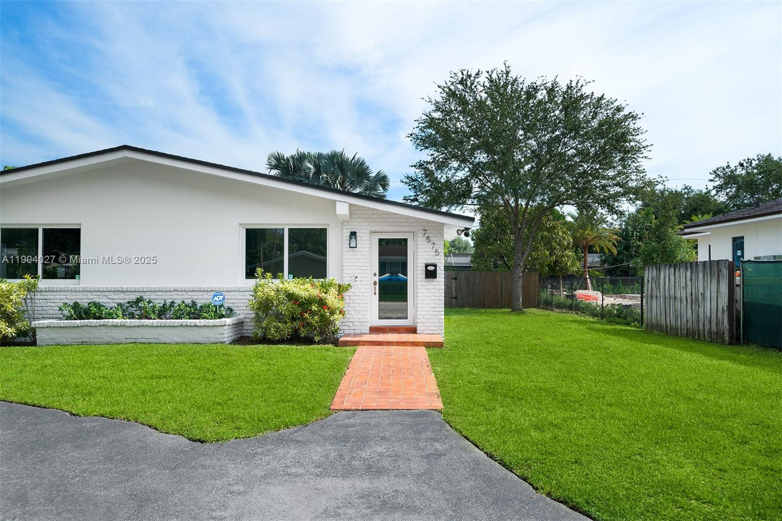 7575 Southwest 134th Street Pinecrest, FL 33156 - Photo 3 of 28 a front view of house with yard and green space