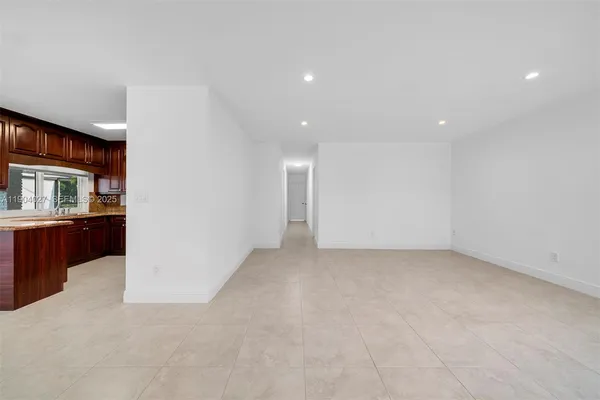 a view of an empty room with entrance and windows