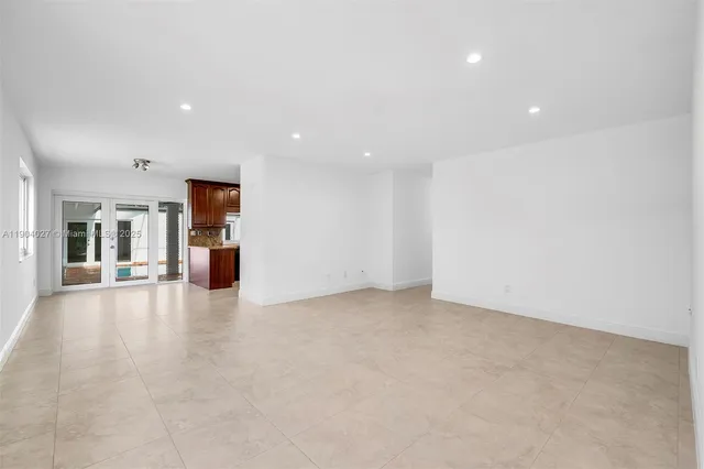 a kitchen with stainless steel appliances granite countertop a refrigerator a stove and a sink with wooden cabinets