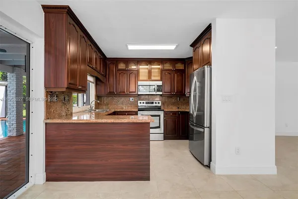 a kitchen with stainless steel appliances granite countertop a sink stove and microwave