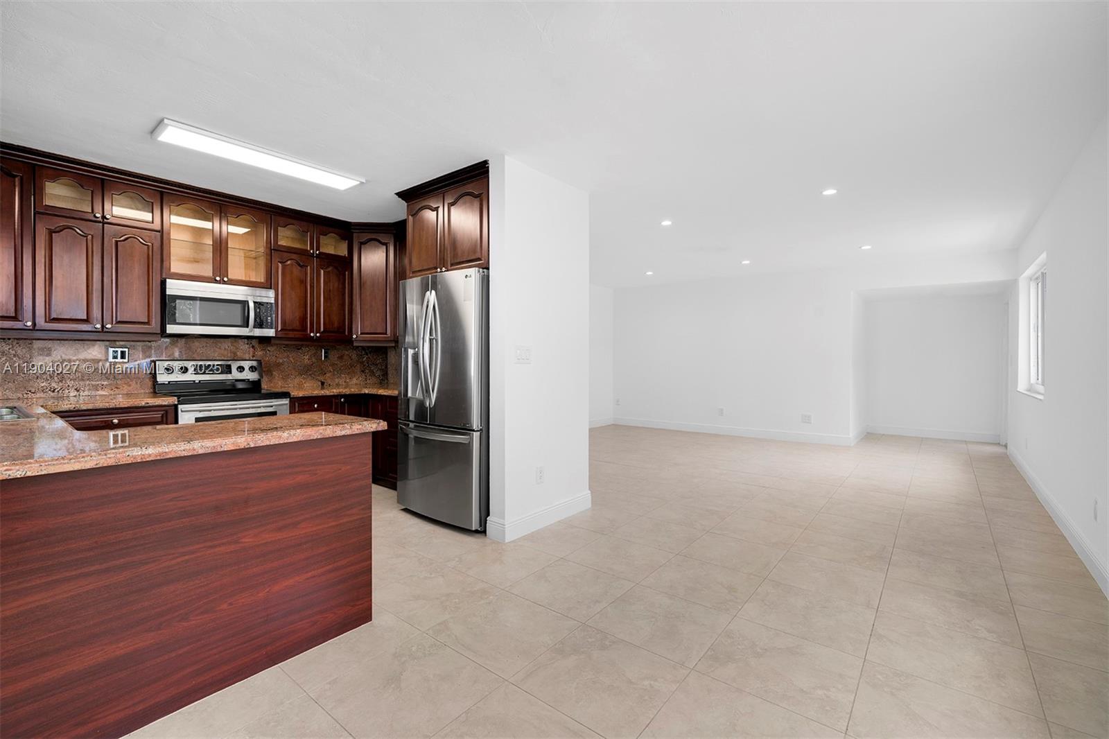 7575 Southwest 134th Street Pinecrest, FL 33156 - Photo 8 of 28 a kitchen with stainless steel appliances a refrigerator and a stove top oven