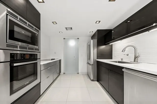 a kitchen with stainless steel appliances a stove a sink and a microwave