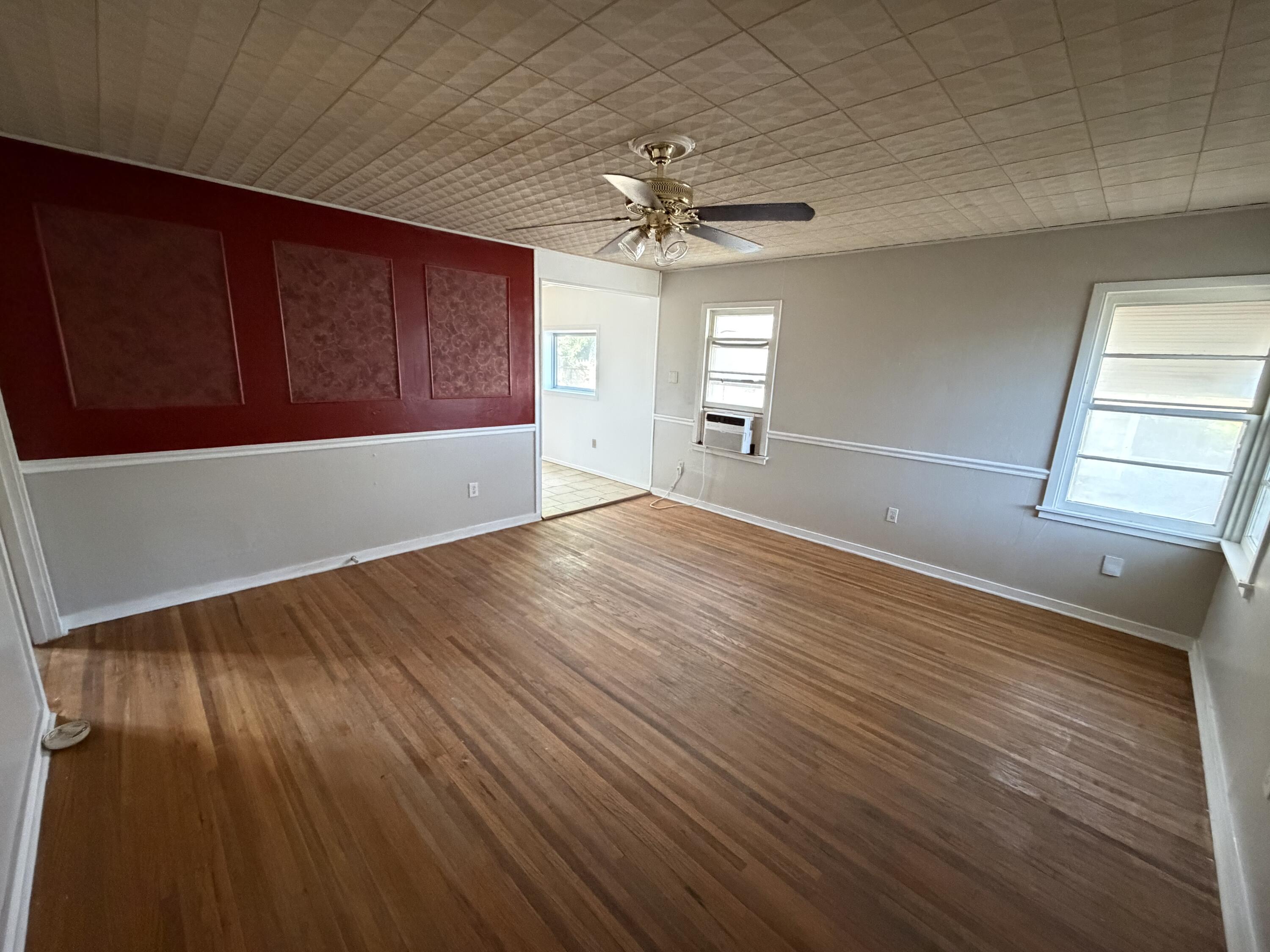 2315 32nd Street Lubbock, TX 79411 - Photo 2 of 9 a view of an empty room with window and wooden floor