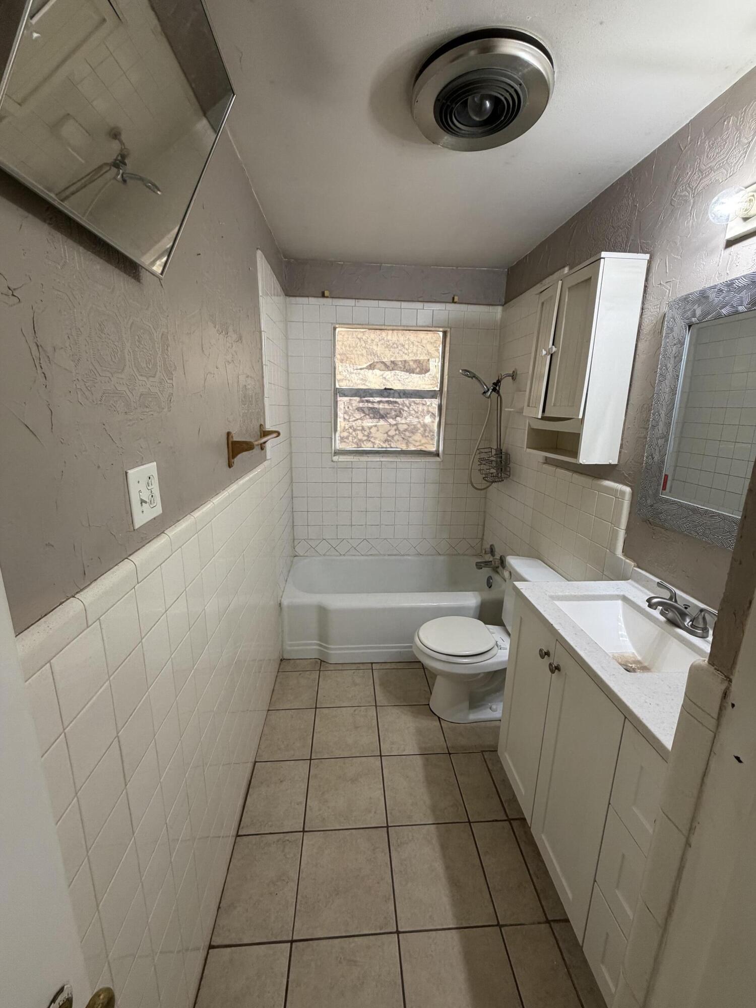 2315 32nd Street Lubbock, TX 79411 - Photo 6 of 9 a bathroom with a sink a toilet and mirror