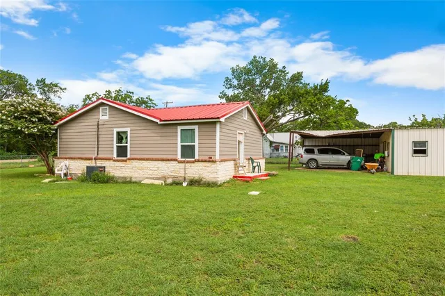 a yellow and red house sitting in middle of the grass