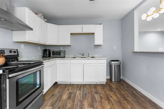 a kitchen with wooden floor and a stove top oven