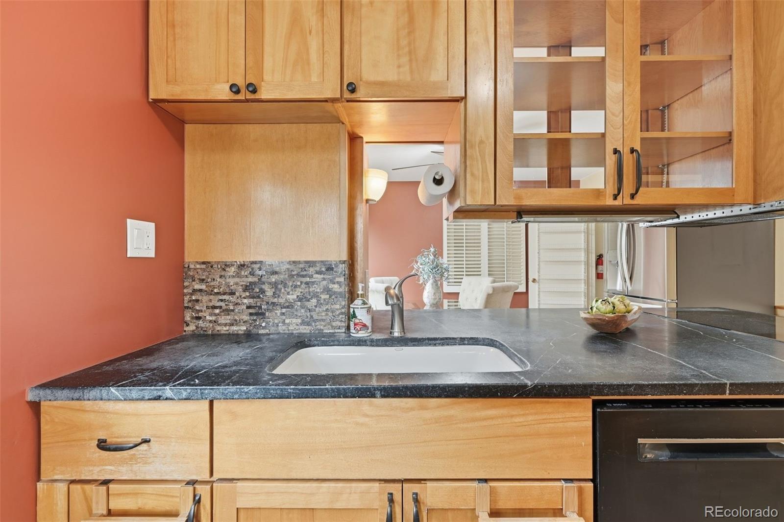 2002 West Ridge Road Littleton, CO 80120 - Photo 11 of 50 a kitchen with granite countertop a sink a stove and cabinets